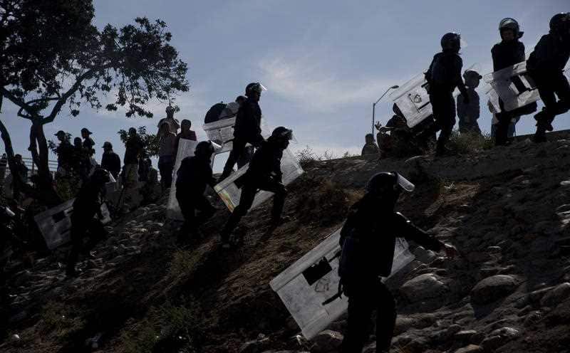 Mexican police spread out as they try to keep migrants from getting past the Chaparral border crossing in Tijuana, Mexico.