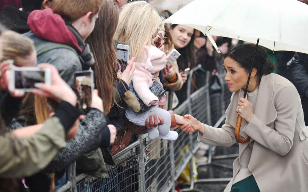 Meghan Markle greets crowds with Prince Harry (not pictured) during a walkabout.