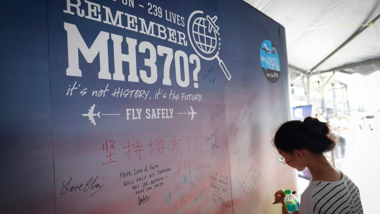 A girl writes a condolence message during the Day of Remembrance for MH370 event in Kuala Lumpur, Malaysia.