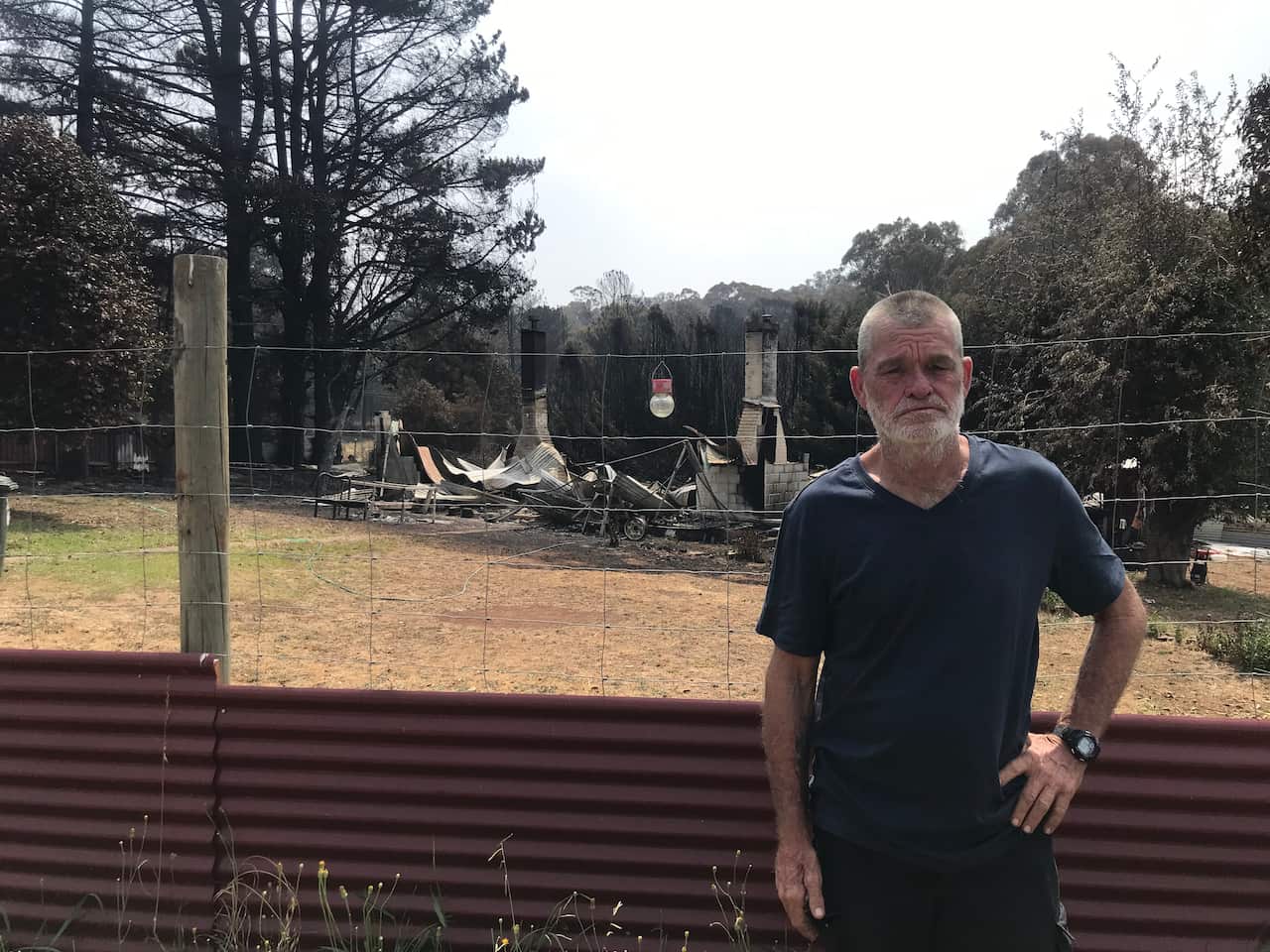 Mick Gardener in front of his destroyed home. 