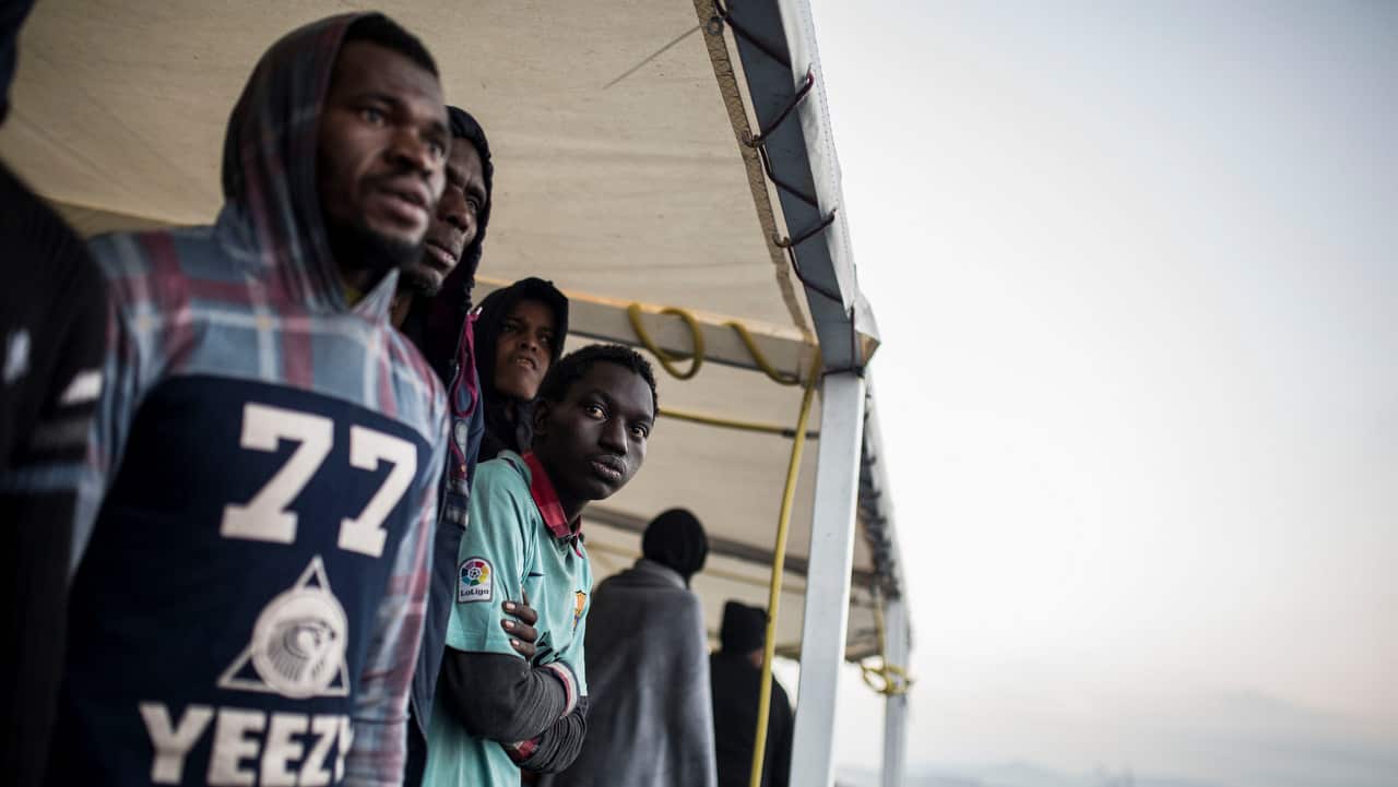 Migrants look out from the deck of the Spanish NGO Proactiva Open Arms rescue vessel, after being rescued 21 December 2018.