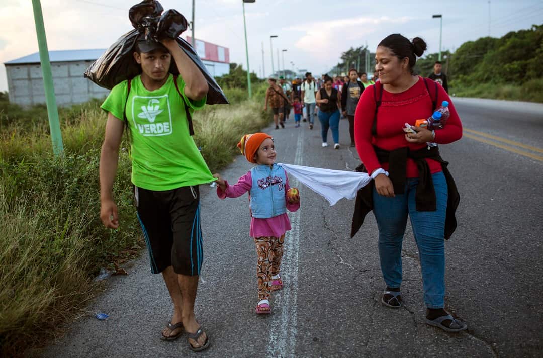 Honduran migrants with their 4-year-old daughter tied to her mother with a piece of cloth so she doesn't get lost in the crowd. 