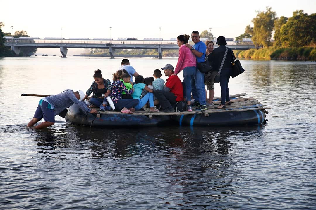 Honduras migrants use a raft to speed up their journey. 