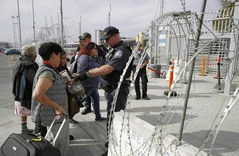 Migrants from Central America have their backgrounds checked in Tijuana on the Mexican side of the border with the United States.