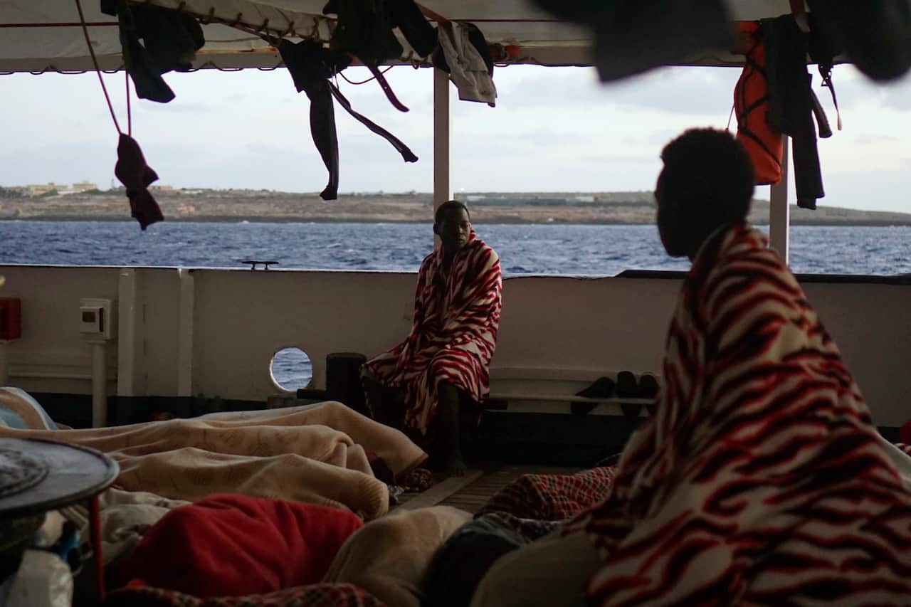 Migrants sit aboard the Open Arms Spanish humanitarian boat (AAP)