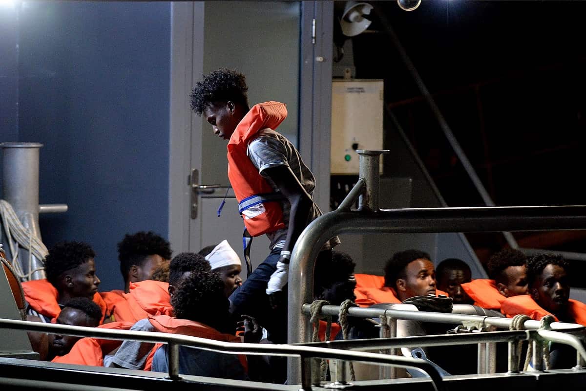 Migrants sit in a patrol boat as they are brought into Valletta, after being transferred onto the Maltese patrol boat on July 7, 2019.