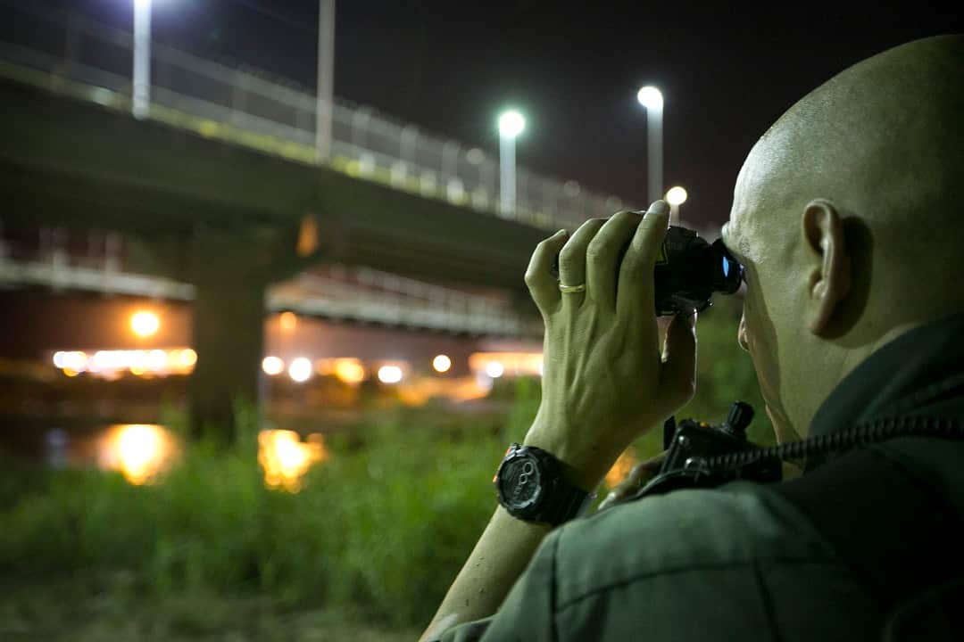 In this Wednesday, July 23, 2014 file photo, a U.S. Border Patrol agent keeps watch in Roma, Texas, across the Rio Grande River from Ciudad Miguel Aleman, Tamaulipas, Mexico. (AP Photo/Austin American-Statesman, Jay Janner)