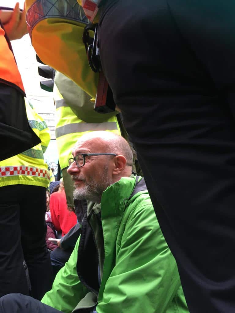 Mike sits after being arrested