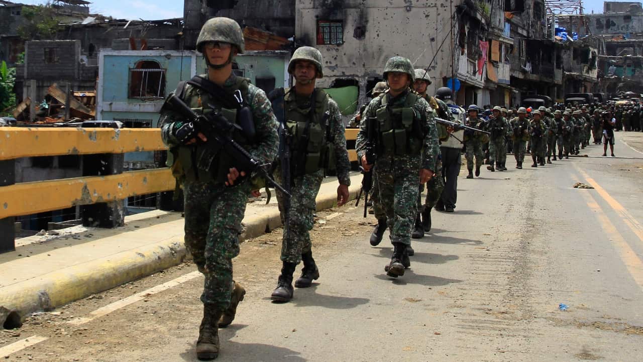 Philippine soldiers march on a bridge in Marawi City, Mindanao Island, southern Philippines on 30/8/17.