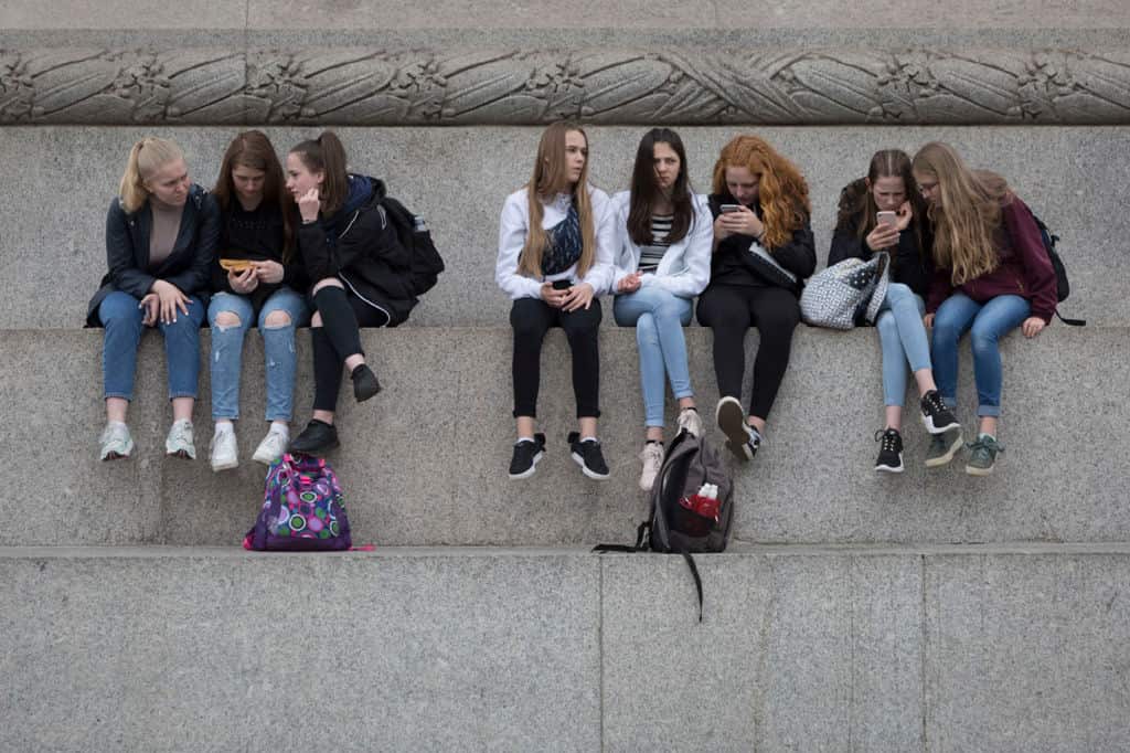 A group of teenagers on their mobile phones.