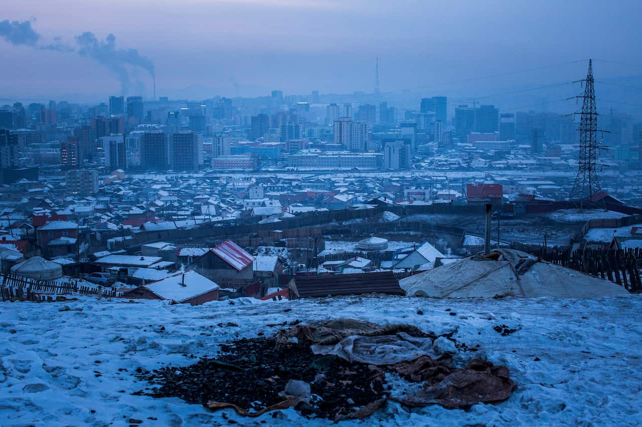 A pile of coal exposed in the snow on an abandoned lot in Ulaanbaatar, Mongolia.