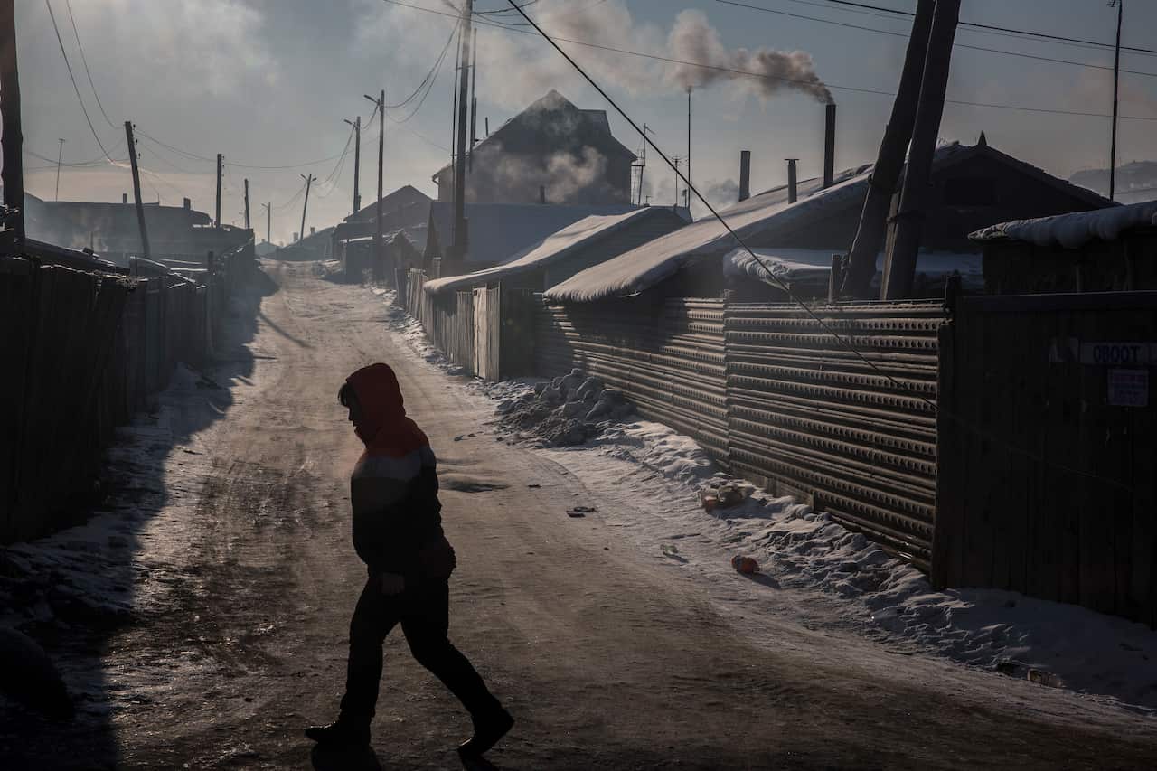 On a day of heavy pollution, a resident walks through the Bayankhoshuu District of northern Ulaanbaatar, Mongolia.