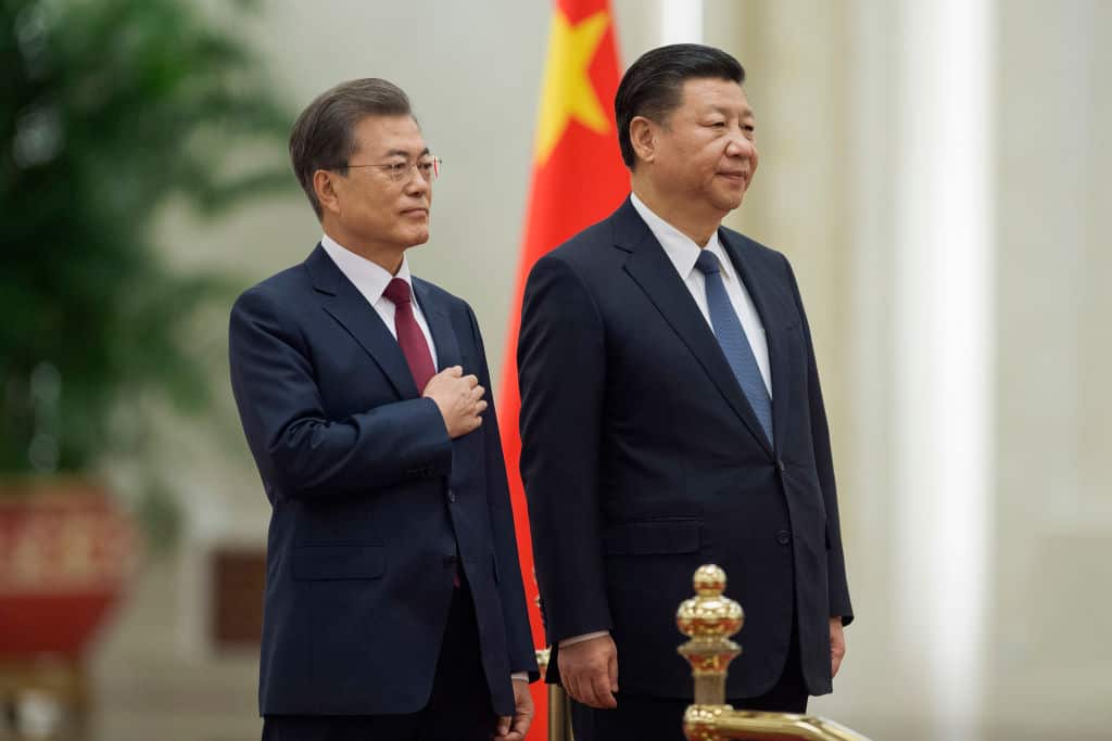 South Korean President Moon Jae-In (L ) and Chinese President Xi Jinping (R) listen to the South Korean anthem at the Great Hall of the People.