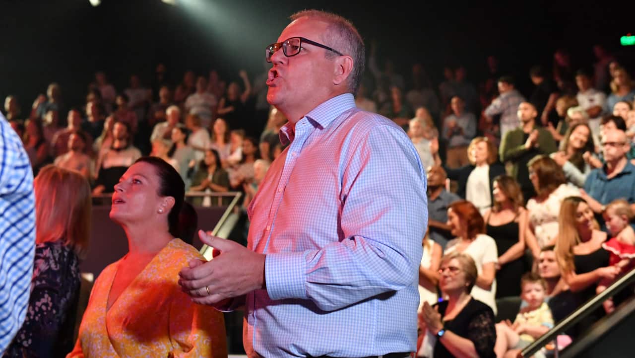 Prime Minister Scott Morrison and wife Jenny sing during an Easter Sunday service at the Horizon Church. 