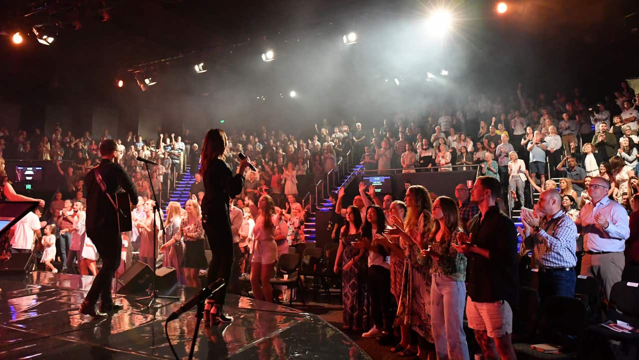 Prime Minister Scott Morrison and wife Jenny (right) sing during an Easter Sunday service at his Horizon Church.