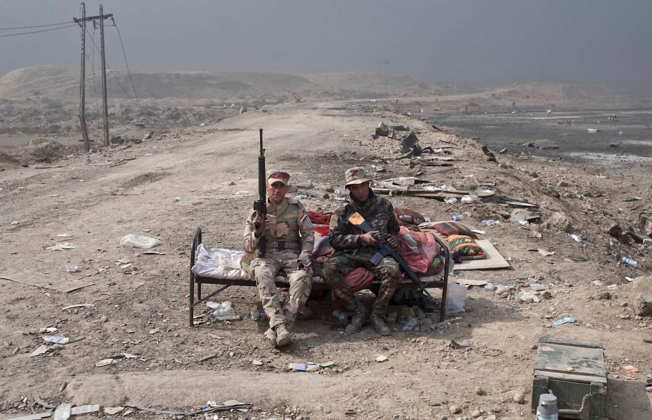 Iraqi army soldiers rest at a checkpoint in Qayara, some 50 kilometers south of Mosul, Iraq, Wednesday, Oct. 26, 2016.