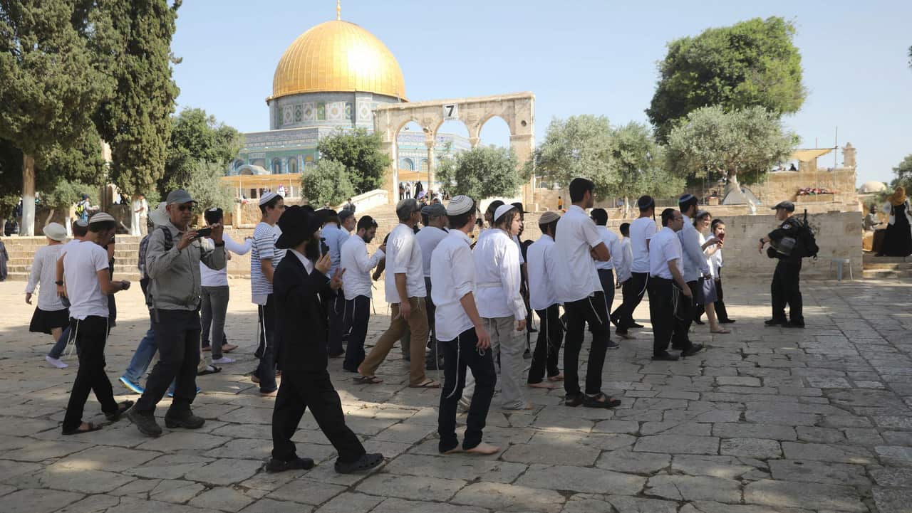 Israeli police officers escort a group of religious Jews near the Dome of the Rock Mosque in the Al Aqsa Mosque compound.