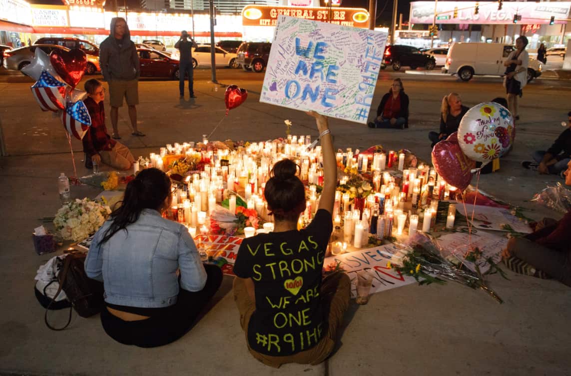 Mourners pay tribute at a makeshift memorial on the Las Vegas Strip for the victims of a mass shooting.
