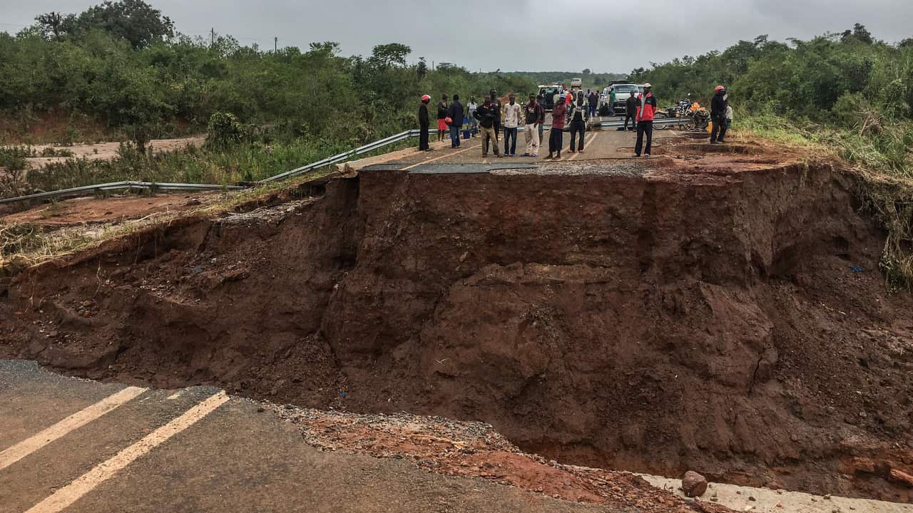 People stand near a damaged bridge over river Munhinga after the passage of the cyclone Idai in Sussudenga district, Manica province, central Mozambique.