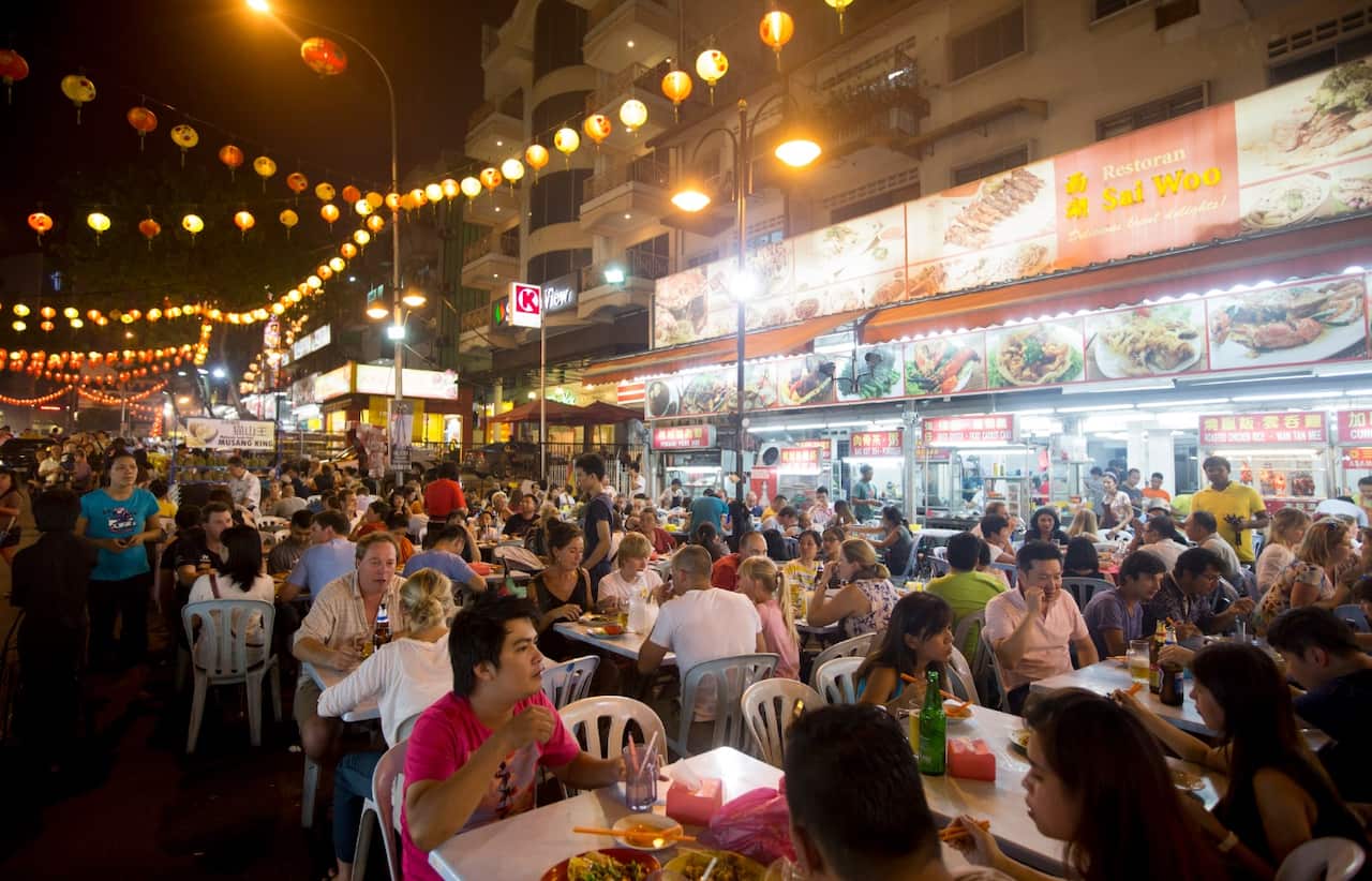 People sit at outdoor restaurants at the Jalan Alor food street in Kuala Lumpur, Malaysia, on Monday, July 21, 2014.
