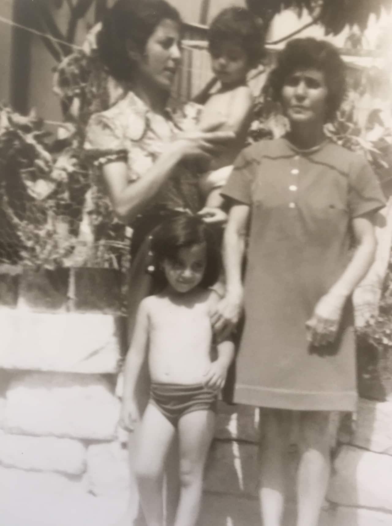 Saab hasan being held by his mother Behiye, grandmother Lutfiye standing with sister Saver 