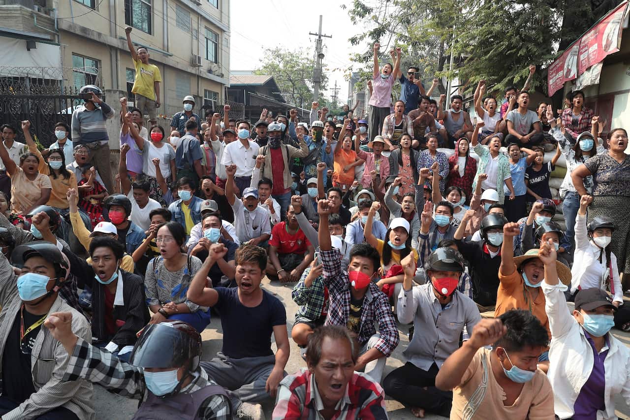 Protesters raise their hands with clenched fists during an anti-coup demonstration in Mandalay, Myanmar on 13 March 2021.