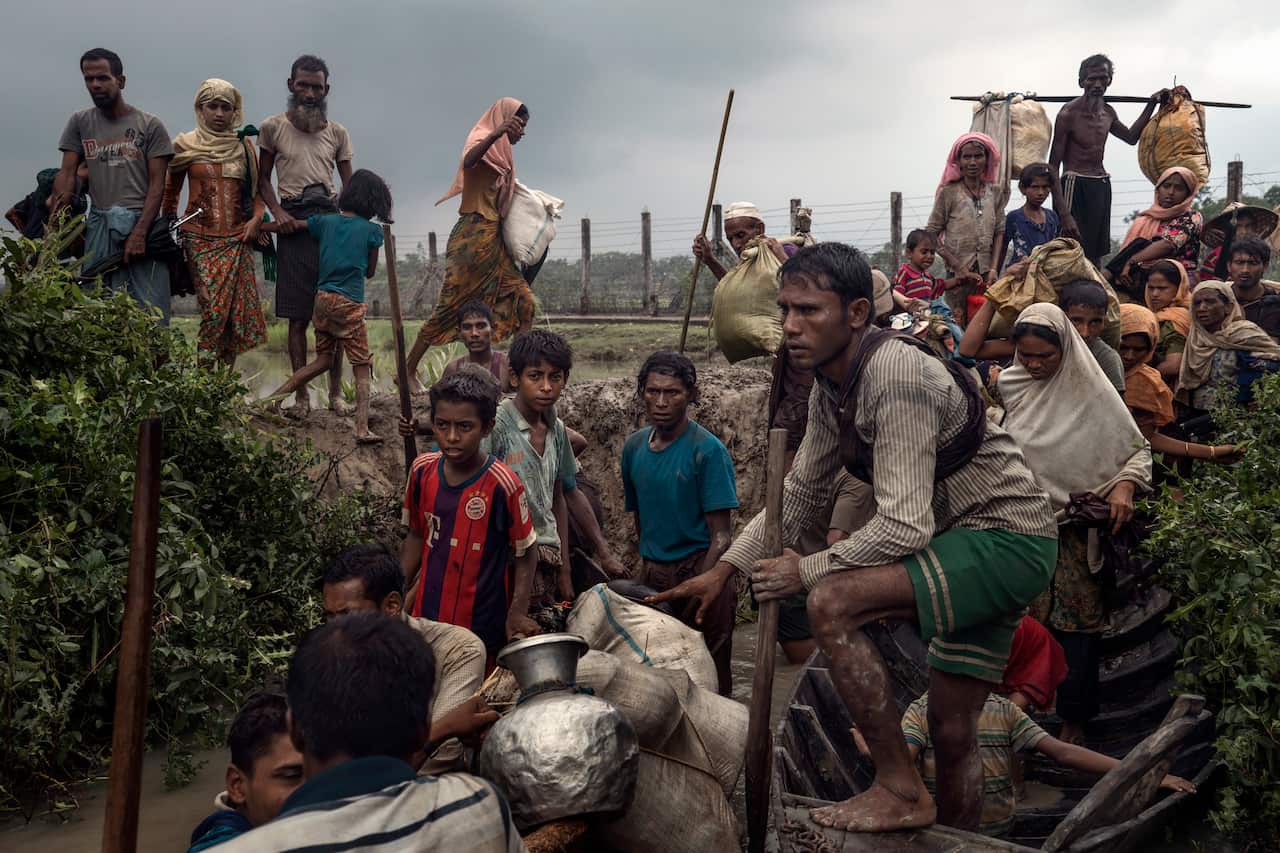 Rohingya refugees wait to board boats to flee to Bangladesh, on the bank of the Naf River, near Tumbru, Myanmar.