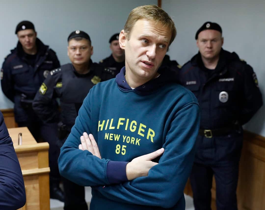 Russian opposition leader Alexei Navalny, foreground, waits during a break in the hearing on his appeal, in a court in Moscow, Russia, Wednesday, Oct. 3, 2018. (AP Photo/Pavel Golovkin)