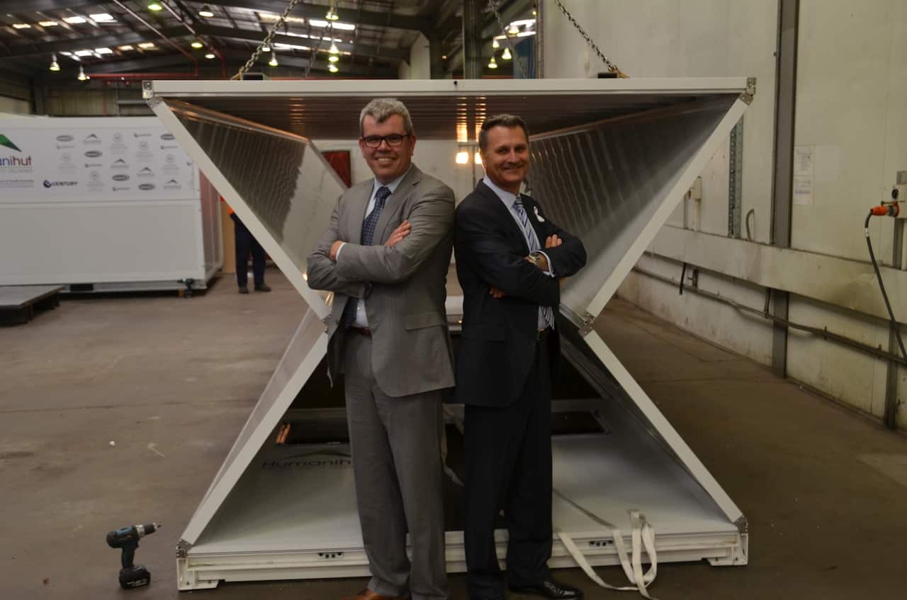 Andrew Hamilton and Neale Sutton of Humanihut in front of a partially collapsed emergency shelter.