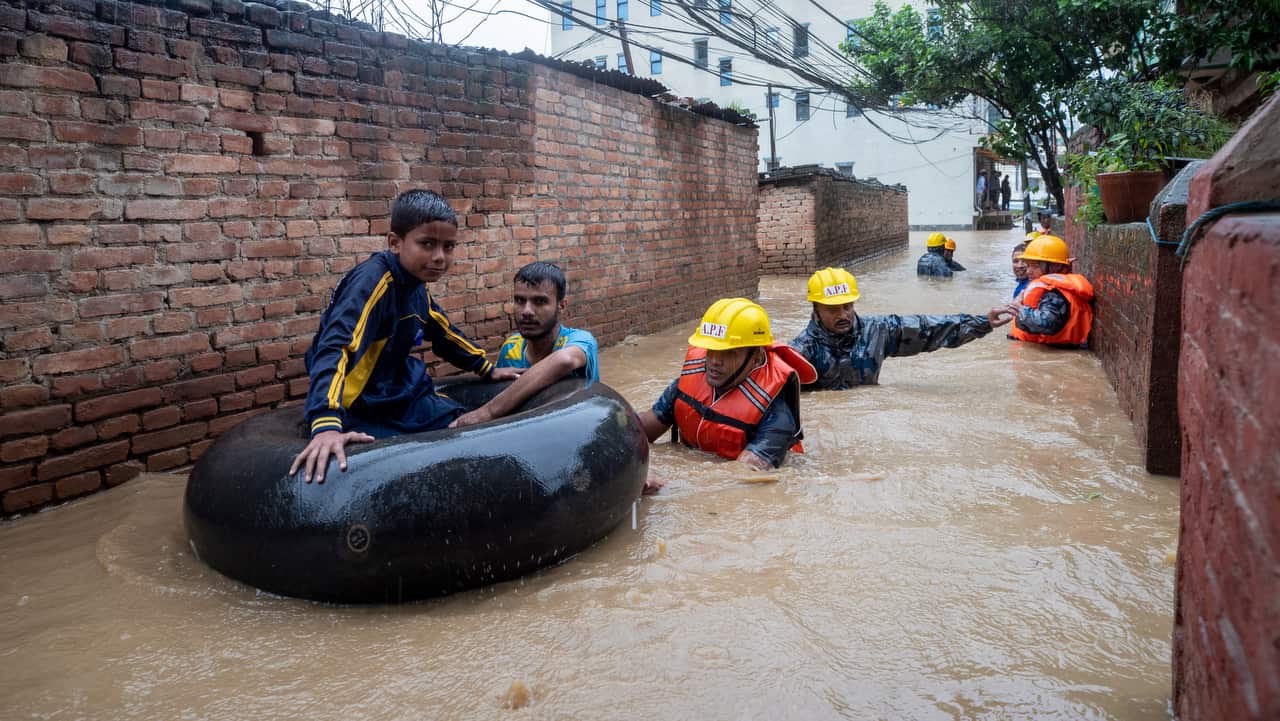 Members of armed police force rescue people from flooded houses following torrential rains in Kathmandu, Nepal.