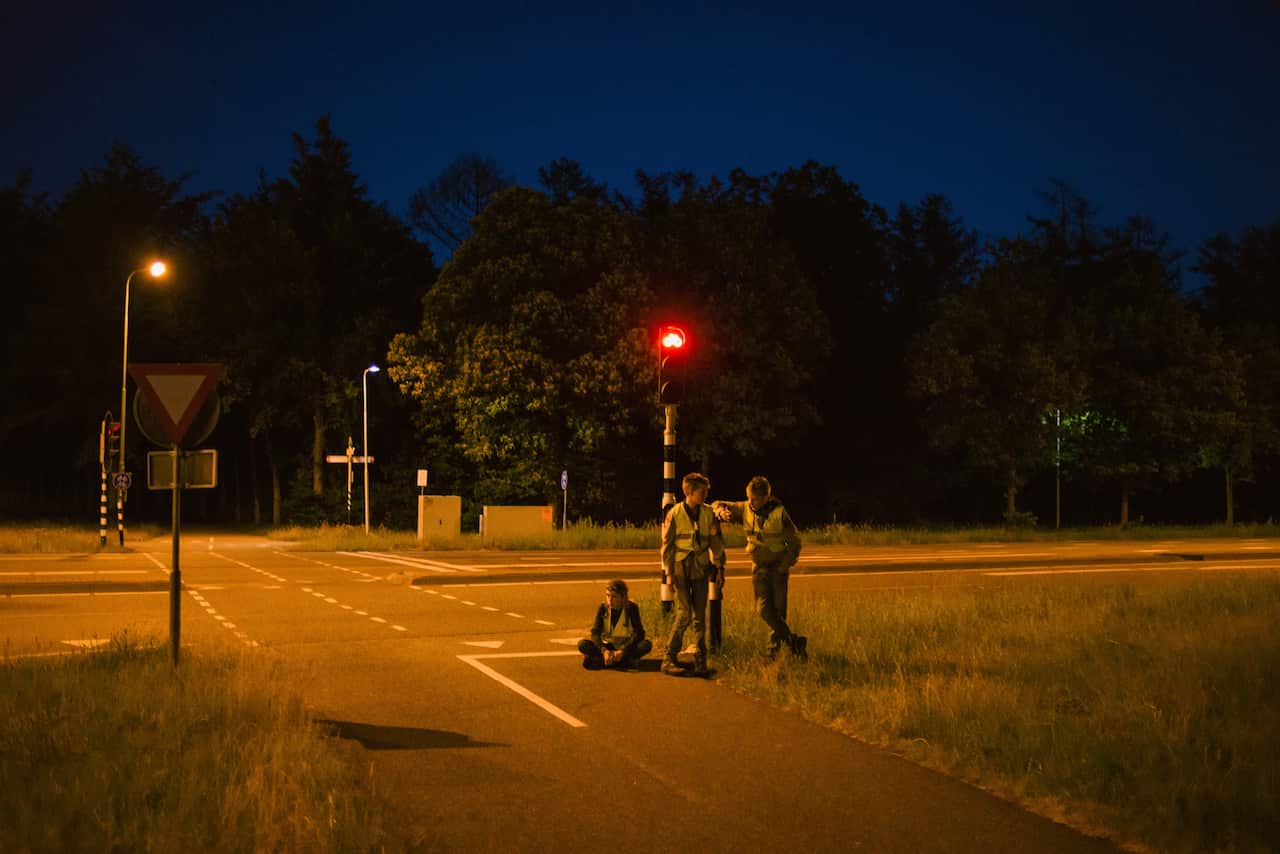 A group of scouts pause while participating in a Dutch tradition known as "dropping," where groups of children are deposited in a forest and have to find their way back to base, near Utrecht, Netherlands. (Dmitry Kostyukov/The New York Times)