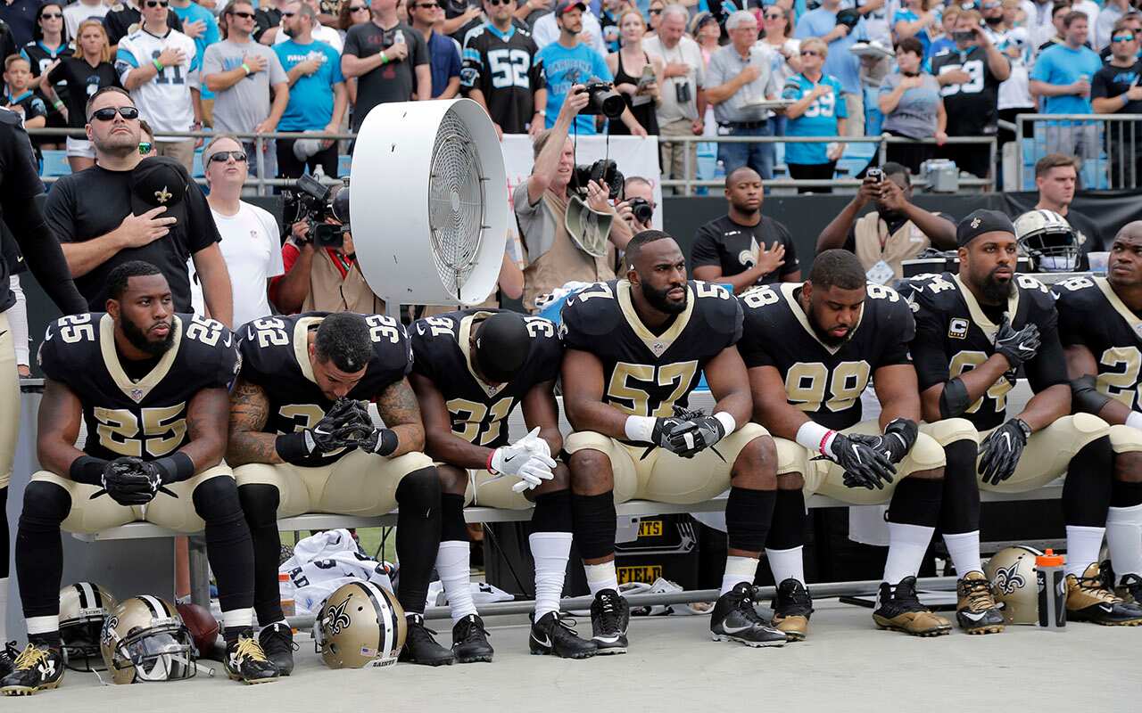 New Orleans Saints players sit on the bench before game against Carolina Panthers in Charlotte. 