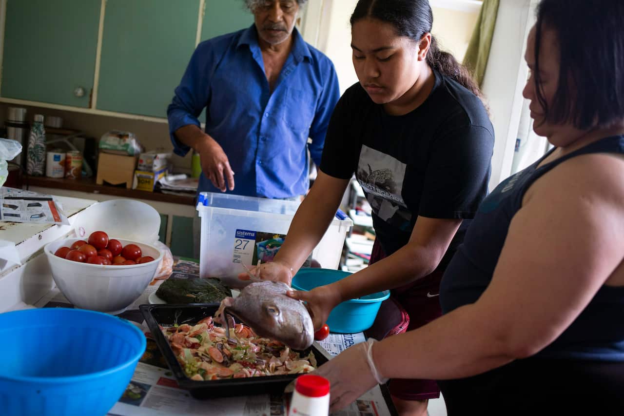 The Lataimaumi family, from left, Uhiua, Lesieli and Mele, prepare an evening meal 