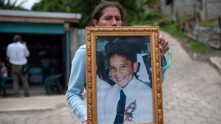 A woman holds a photograph of Bryan Picado during his funeral after he was killed when police and paramilitaries attacked a barricade.