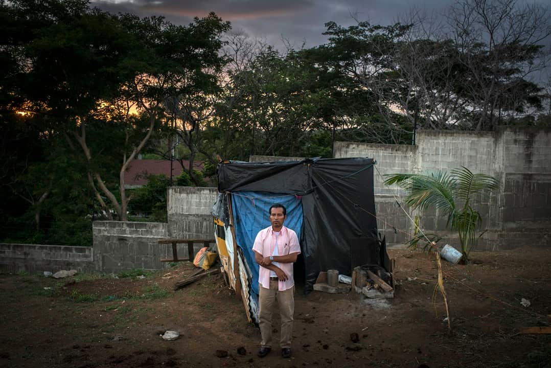 Alejandro Guardado stands in front of the shack where he lives, on the outskirts of Managua, Nicaragua.