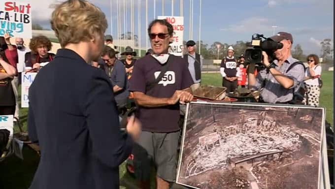 Nick Hopkins with a photo of his destroyed property.