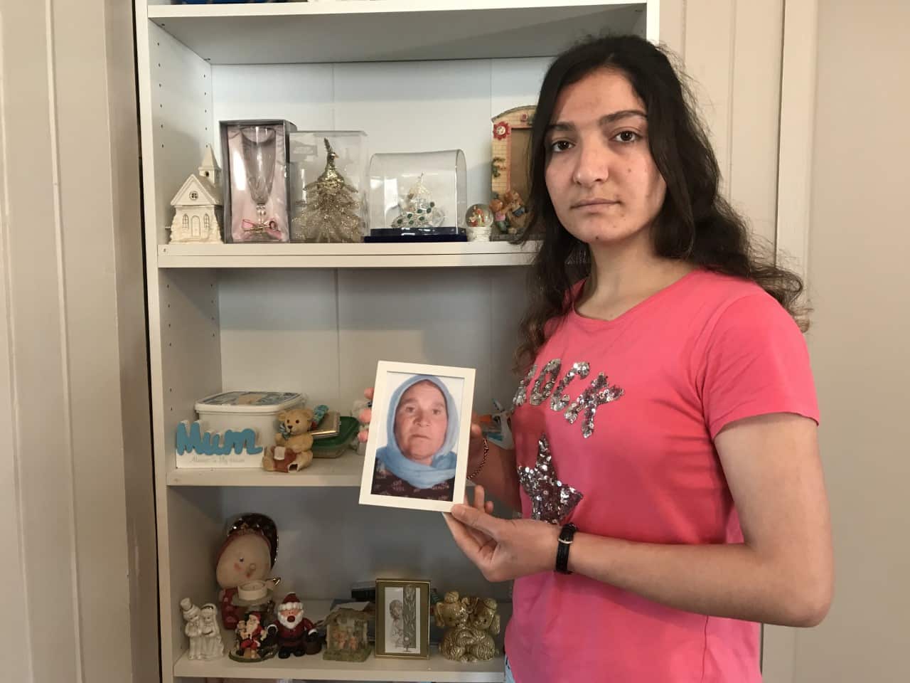 Nihad Barakat al-Awsi with a picture of her mother, who is still living in Iraq.