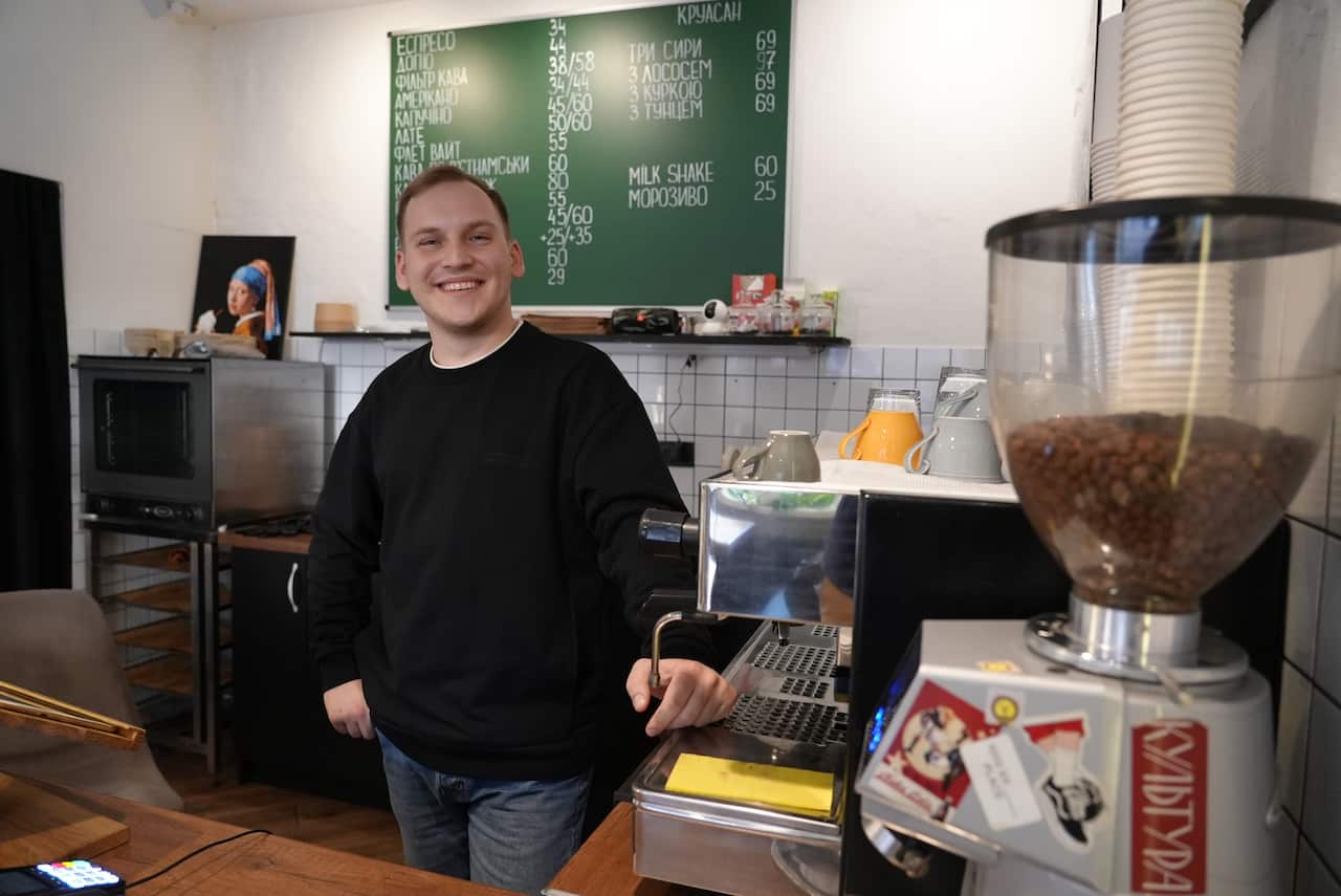 In a stylish Kyiv coffee shop, Nikolai Litvinenko is busy making lattes and selling pastries.