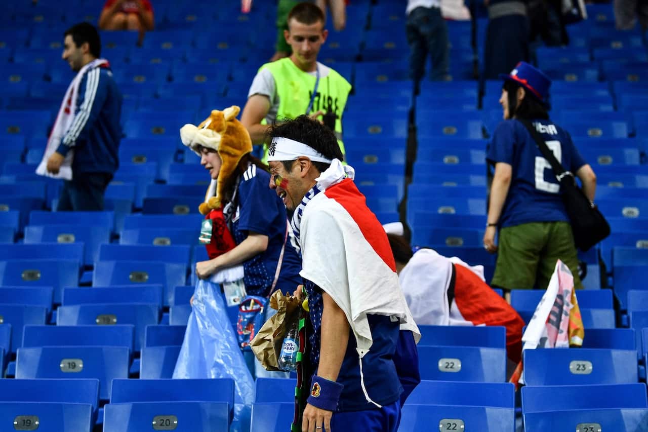 Heartbroken Japanese fans clean the stadium's stand after Japan was defeated by Belgium in the Round of 16 during the 2018 FIFA World Cup in Rostov, Russia, 2 July 2018
