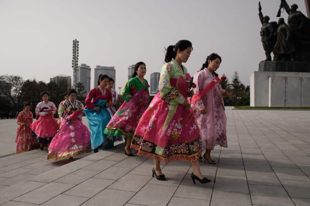 Women carrying flowers arrive at Mansu hill to pay their respects before the statues of late North Korean leaders Kim Il-Sung and Kim Jong-Il.