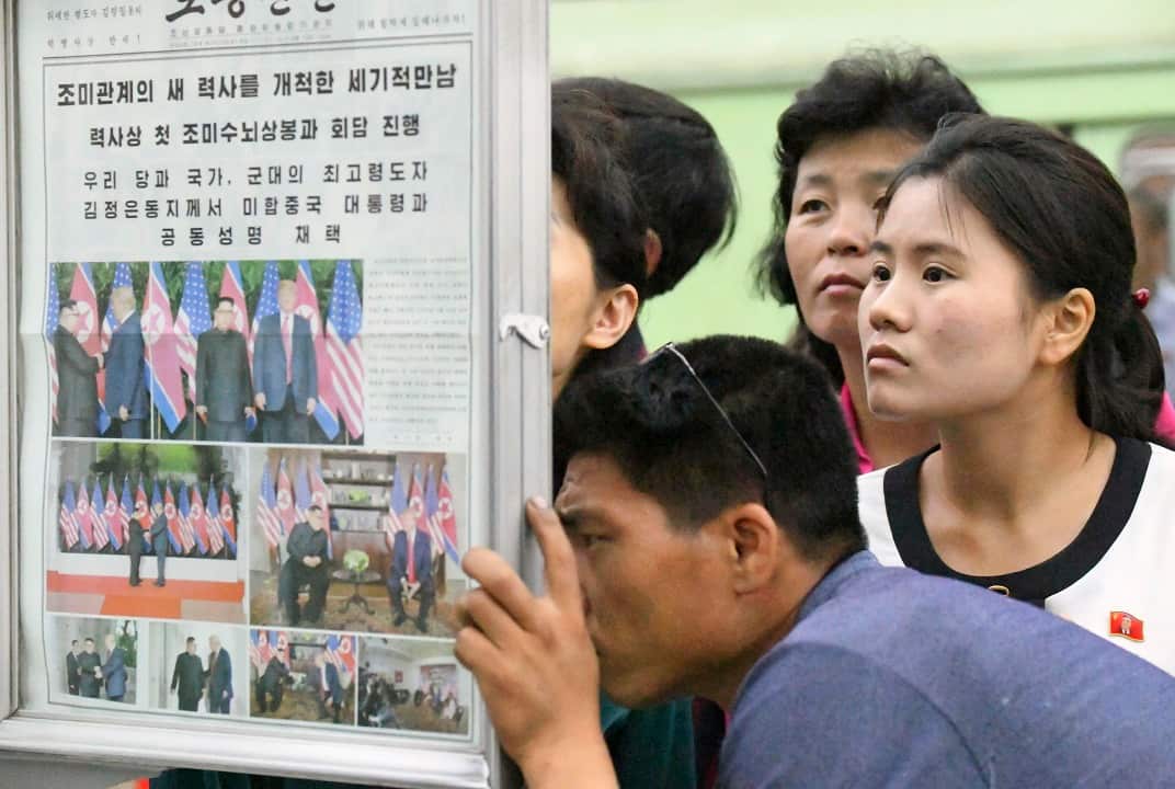 People gather to read the official newspaper of North Korea's ruling Workers' Party at a subway station in Pyongyang.