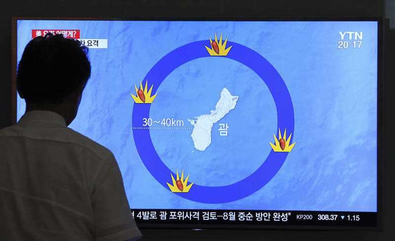 A South Korean man watches a TV screen showing a local news program reporting on North Korea's threats to strike Guam with ballistic missiles