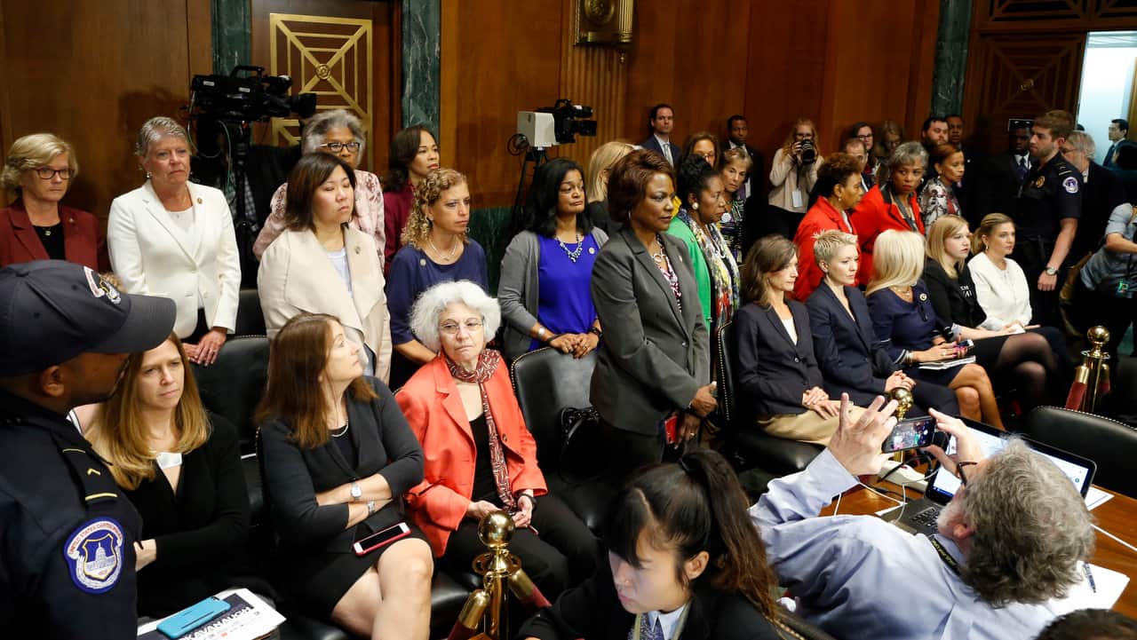 Democratic members of the House of Representatives stand up to show disapproval during the Senate Judiciary Committee vote on the nomination of Brett Kavanaugh.