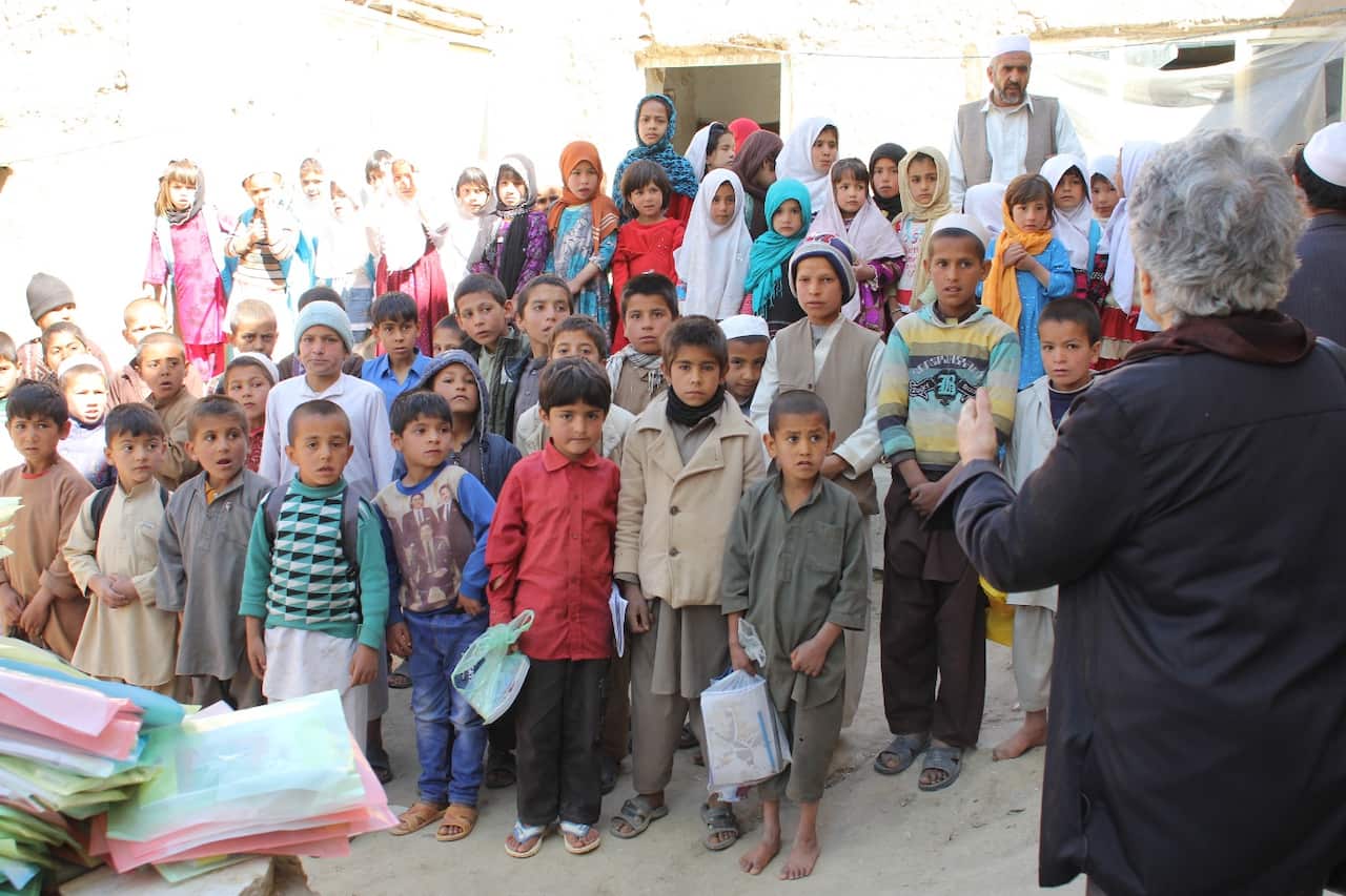 Dr Salehi distributing stationery to orphaned children in Kabul.
