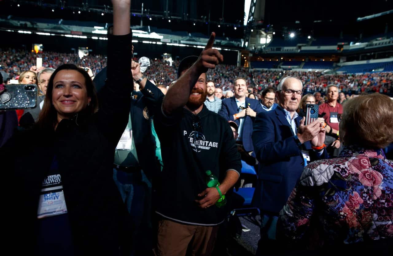 A man points at President Donald Trump after he tossed his cellphone toward the stage as Trump arrived to speak