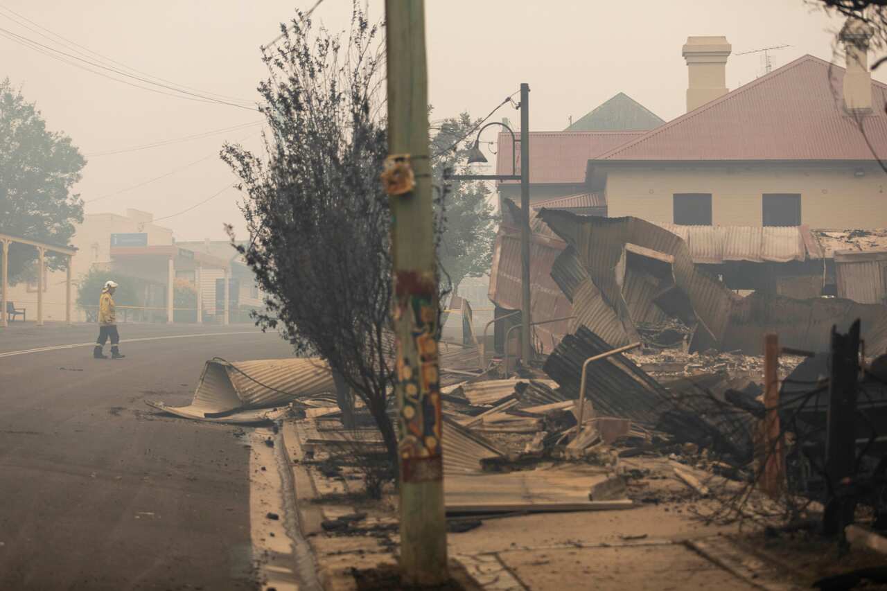 Firefighters inspect fire damage in Cobargo, NSW.
