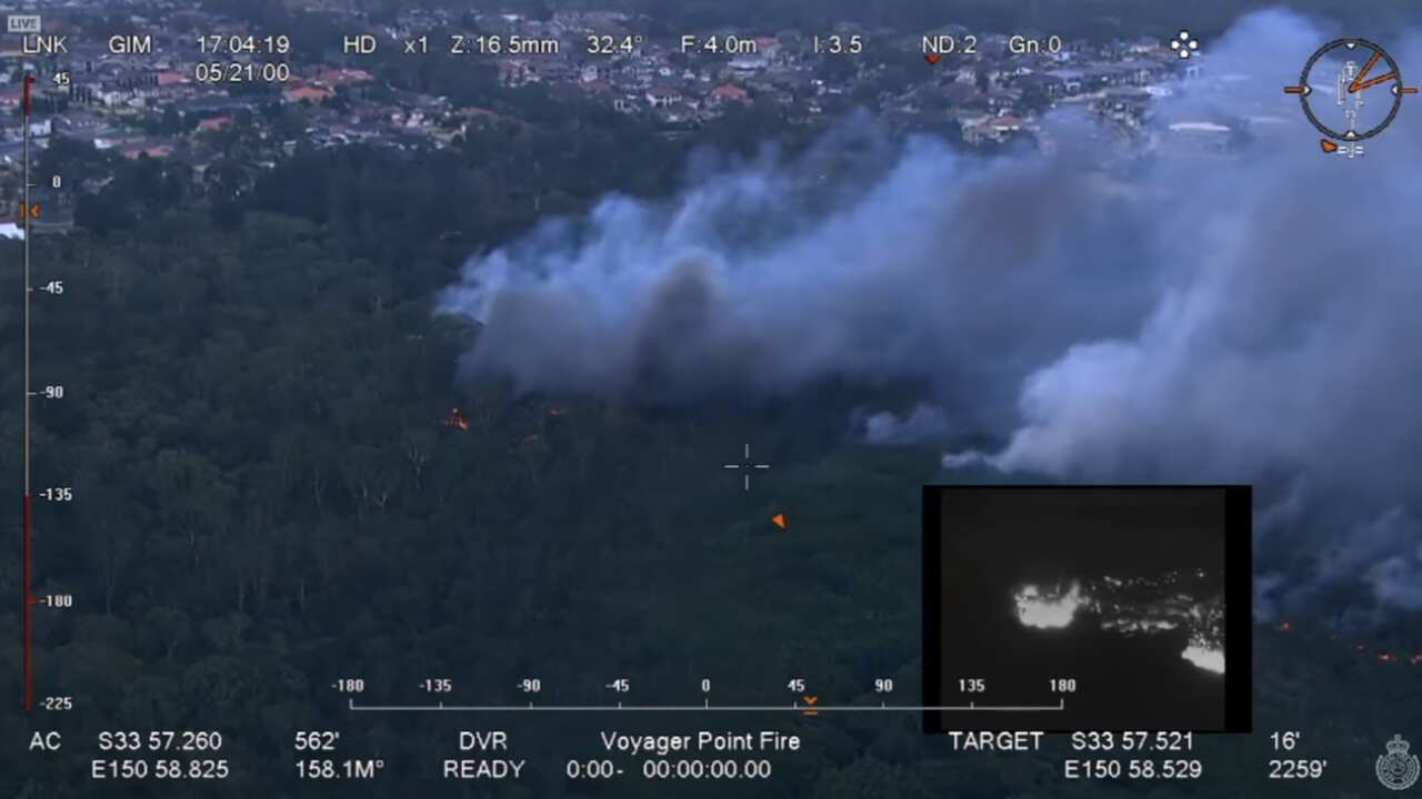 The Voyager Point fire in Liverpool continues to burn in bushland west of the Georges River. 