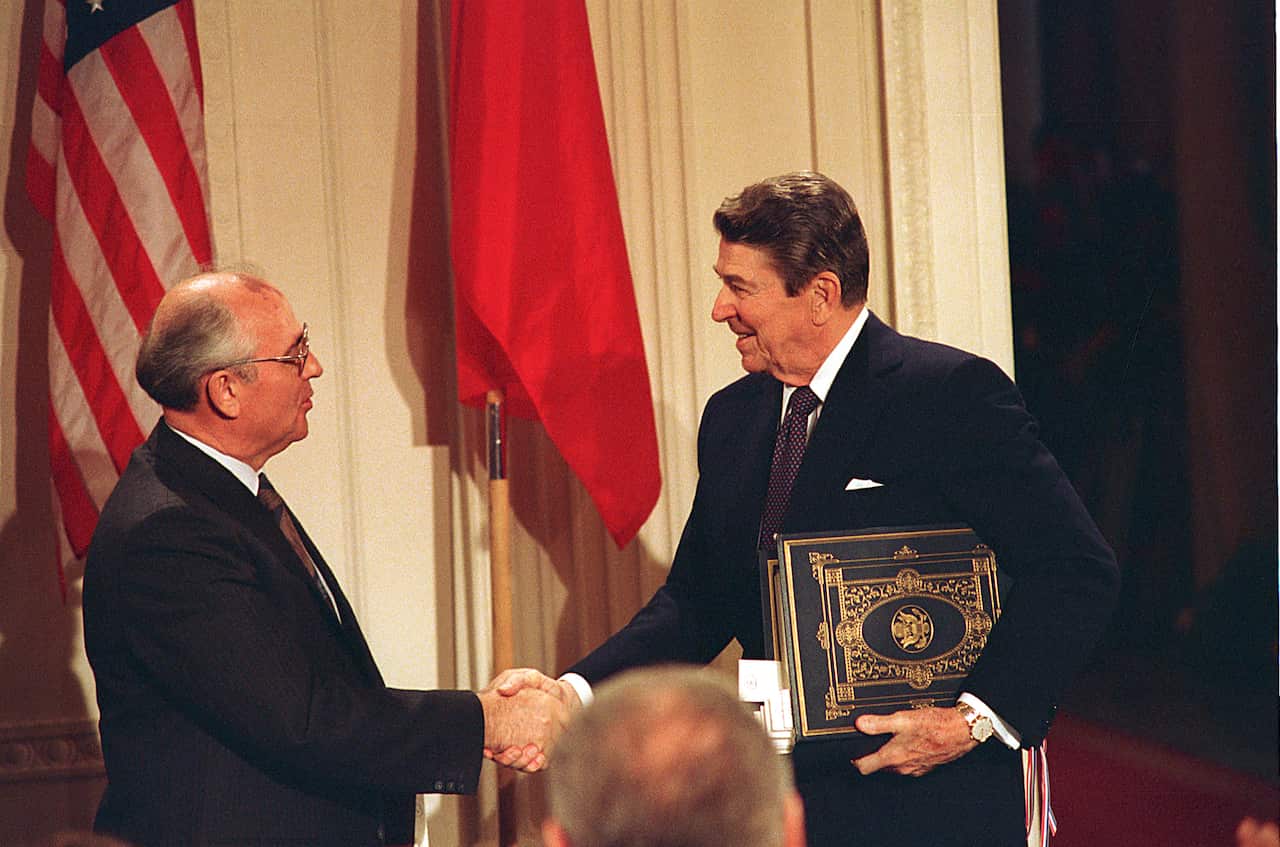 President Ronald Reaganshakes hands with Mikhail Gorbachev after the leaders signed a treaty during a ceremony in the White House East Room in Washington DC.