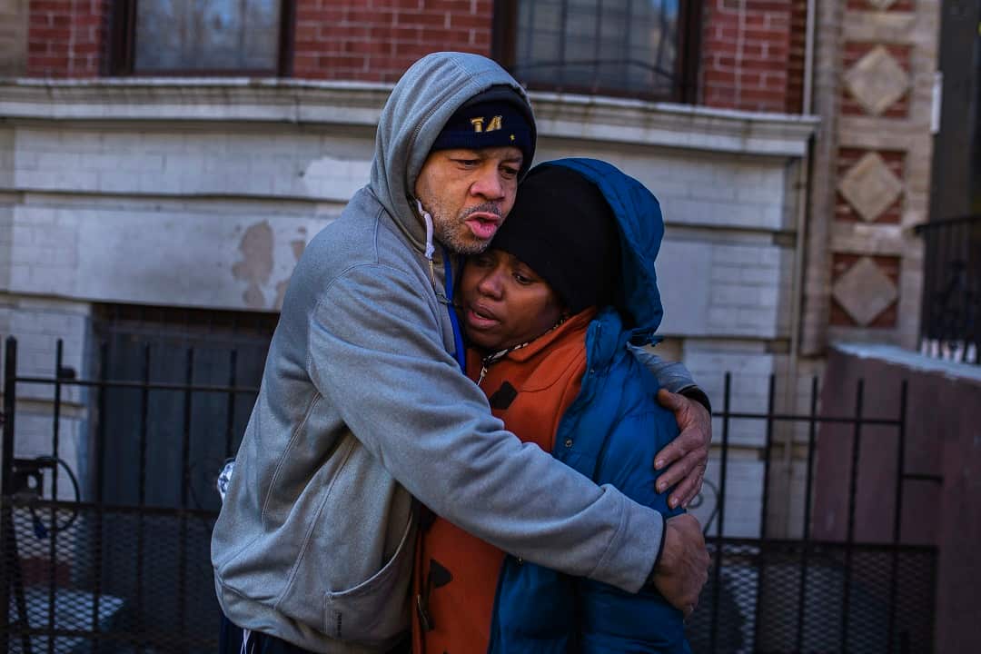 Emelia Ascheampong, 42, right, a resident of the building is comforted by a friend after the fire that claimed the lives of 12 people.