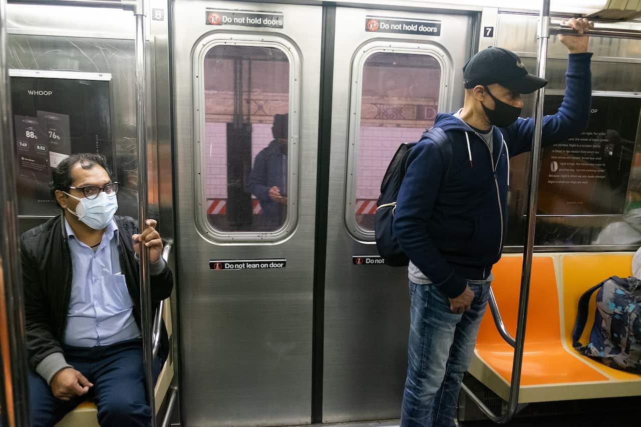 Two commuters wearing face masks as a precaution at the NYC subway amid the coronavirus pandemic.